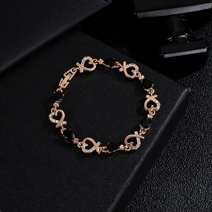 Rose gold heart bracelet with black teardrop stones and zircon accents on black box