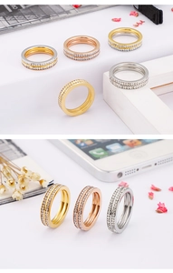 Macro detail of gold and silver double row crystal pavé stainless steel rings on white