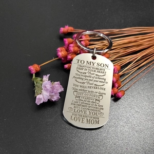 Macro shot of silver stainless steel dog tag keychain with engraved inspirational mom to son text