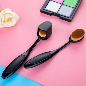 Detail of oval toothbrush foundation brush with black protective cover and dense bristles