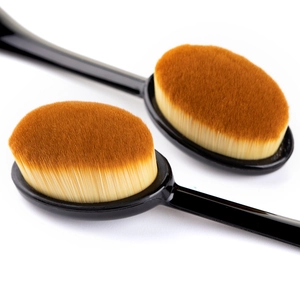 Oval toothbrush-style foundation brushes with dense brown bristles and ergonomic black handles