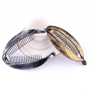 Black and gold banana hair clips with vintage texture shown in a cross arrangement