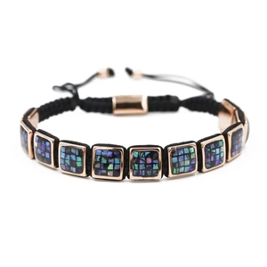 Detailed macro view of hand-woven rose gold bracelet with iridescent shell inlay blocks