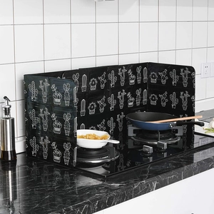 Foldable black kitchen oil splash guard with white cactus pattern on marble countertop