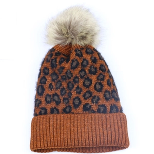 Close-up of leopard print knit beanie featuring a fluffy pom-pom and thick ribbed cuff