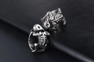 Macro shot of two silver skull rings on a premium black leather texture background