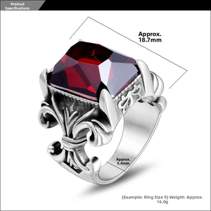Macro shot of vintage titanium steel ring with red gemstone and fleur-de-lis relief