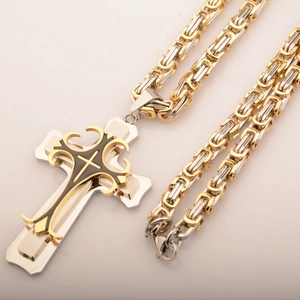 Close-up of dual-tone silver and gold Byzantine chain with cross pendant details