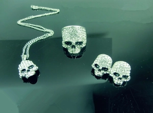 Detailed view of punk skull jewelry set with sparkling rhinestones on black background