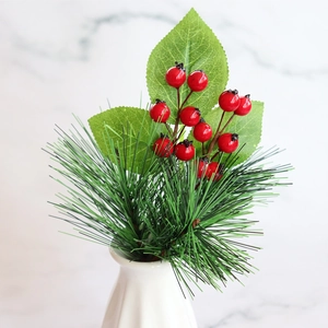 Artificial pine branches with red berries in a white ceramic vase on marble background