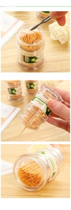 Close-up of double-pointed natural bamboo toothpicks in a clear portable dispenser