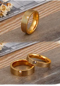 Detail of gold titanium ring featuring four black stripes and a small centered zircon stone