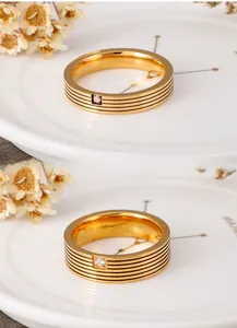 Macro detail of golden titanium ring with parallel grooves and square-cut cubic zirconia