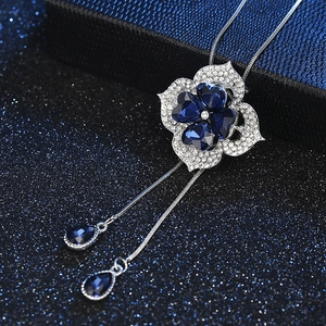 Elegant long necklace featuring a navy blue heart crystal floral pendant on a jewelry box