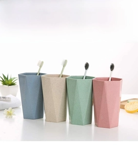 Detailed view of four hexagon-shaped matte toothbrush cups in pastel colors with props
