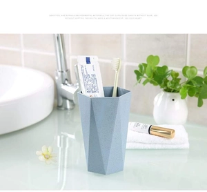 Detail of light blue hexagonal toothbrush cup with matte eco-friendly texture on bathroom sink