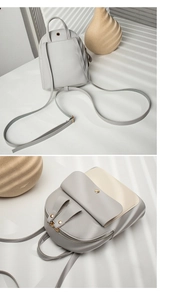 Detail of grey PU leather mini backpack with gold metal buckle and zipper closure