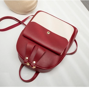 Top view of a two-tone burgundy and cream PU leather backpack with gold rivet details