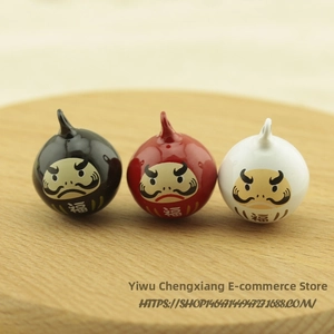 Detailed view of Daruma lucky bell charms in black red and white with gold character