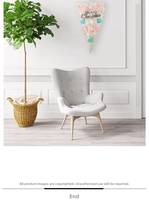 Modern grey fabric wingback chair with wooden legs in a cozy Christmas room setting