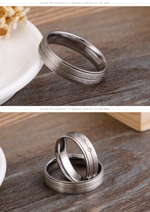 Close-up of matte brushed titanium steel couple rings with minimalist stone inlay