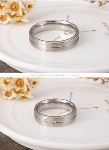 Detail view of silver brushed titanium steel couple rings with three inlaid diamonds