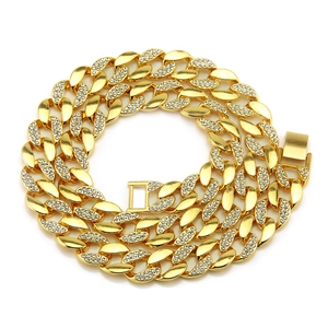 Macro detail of 18K gold plated Cuban link necklace with sparkling crystals and clasp