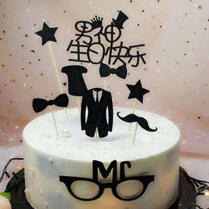 Detail view of black Happy Birthday cake toppers set featuring suit, hat and bowtie theme