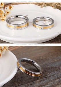 Close-up of two-tone titanium steel couple rings with a centered cubic zirconia stone