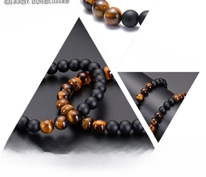 Detail of handmade tiger eye and matte onyx beaded bracelet with natural stone texture