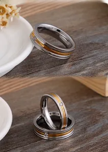 Macro shot of polished titanium steel ring with a gold groove and crystal diamond inlay