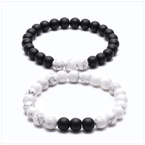 Close-up of matte black lava stone and white marble turquoise beads on couple bracelets