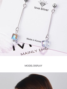Macro shot of long drop earrings with silver finish and iridescent crystal cubes