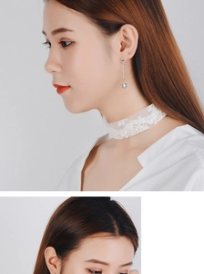 Detail of white lace floral choker and long silver earrings with crystal charms