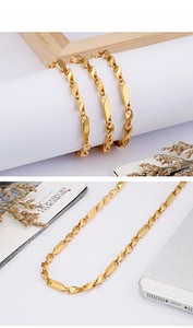 Polished gold titanium steel rhombic chain necklace displayed on a white stand