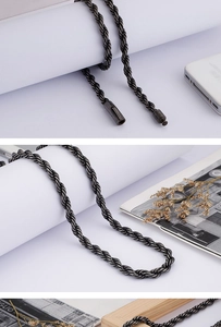 Detail view of a black twisted rope chain necklace on a minimalist lifestyle background