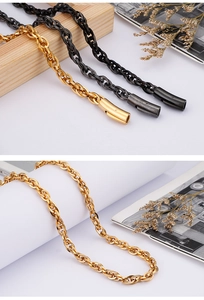 Detailed close-up of stainless steel chains in gold, silver, and black on a wooden stand
