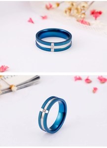 Detail of blue and silver stainless steel ring with a center cross-set single zircon