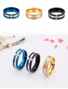 Detailed view of brushed stainless steel rings in blue, gold, and black with inset zircon