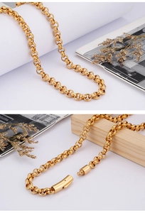 Detail of a gold stainless steel necklace featuring interlocking rings and cylindrical clasp