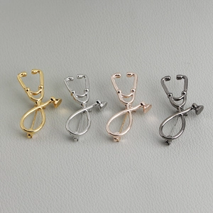 Stethoscope brooches in gold, silver, rose gold and black finishes on textured leather