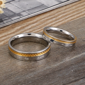 Bagues de couple bicolores argent et or avec gravure sanskrite sur fond bois