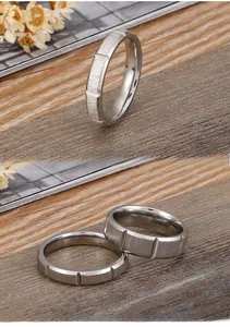 Detail showing brushed stainless steel couple rings with vertical groove design on wood