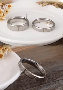 Detail of silver stainless steel rings with brushed finish and vertical geometric grooves