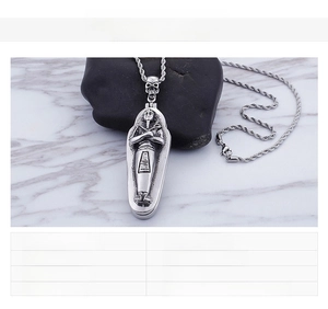 Macro detail of Egyptian pharaoh mummy pendant in vintage stainless steel with rope chain