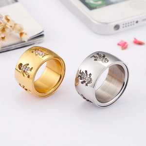 Polished steel ring set with cutout figures and crystal insets in gold and silver