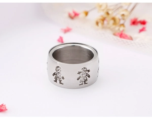 Detail of wide cut-out steel ring featuring boy and girl silhouettes with white stones