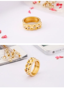 Detail of gold wave rings with round white zircon stones on a clean white background