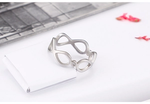 Detailed shot of silver infinity ring with a sparkling crystal on soft fabric