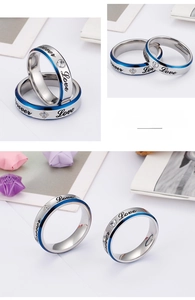 Detail view of Forever Love couple rings with blue edges and engraved lettering on steel